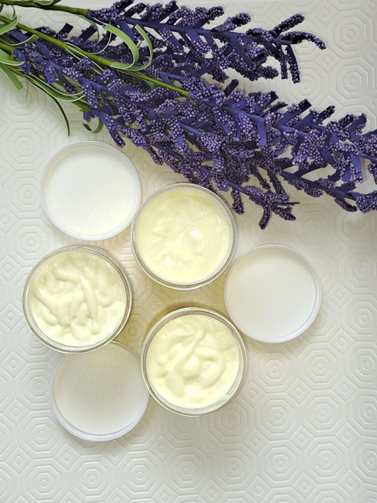 Hydrating skin cream with shea butter in containers with lavender sprigs on a textured background.